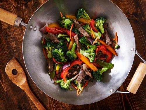 Induction cooking wok with a freshly made stir fry